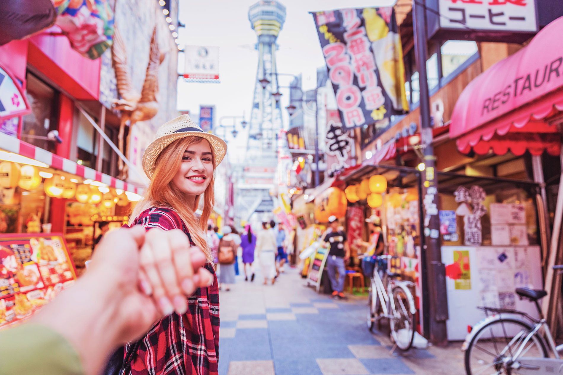 Exploring the streets of Osaka beneath Tsutenkaku Tower, Japan